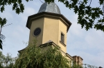 Widok na fragment wieży umieszczonej w elewacji frontowej budynku.