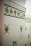 Malowane płytki ceramiczne w pomieszczeniu toalet na poziomie drugiej kondygnacji.